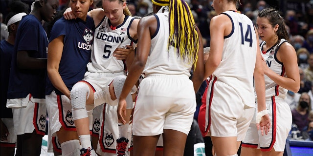 Connecticut's Paige Bueckers is helped off the court after being injured against Notre Dame, domingo, dic. 5, 2021, in Storrs, Connecticut.