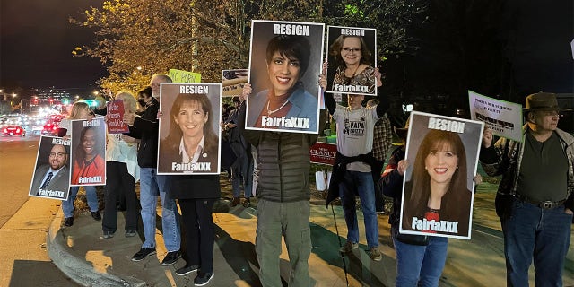 Fairfax County parents protest outside a school board meeting, holding signs reading, "Resign FairfaXXX." Photo credit Tyler O'Neil/Fox News Digital.