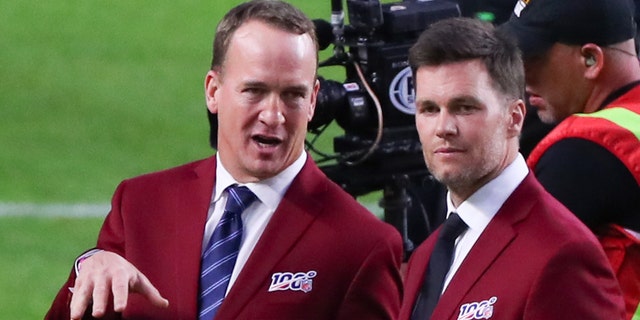Tom Brady and Peyton Manning talk on the field during the 100-year team celebration prior to Super Bowl LIV on Feb. 2, 2020, at Hard Rock Stadium in Miami Gardens, Florida.