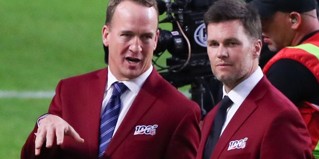 Tom Brady and Peyton Manning talk on the field during the 100-year team celebration prior to Super Bowl LIV on Feb. 2, 2020, at Hard Rock Stadium in Miami Gardens, Florida.