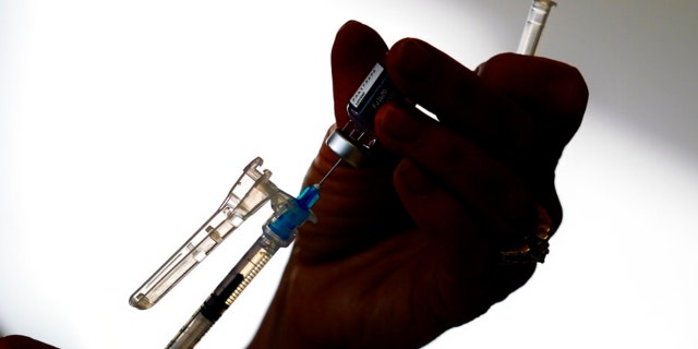 A syringe is prepared with the Pfizer COVID-19 vaccine at a clinic in the Norristown Public Health Center in Norristown, Pa., Tuesday, Dec. 7, 2021. (AP Photo/Matt Rourke)