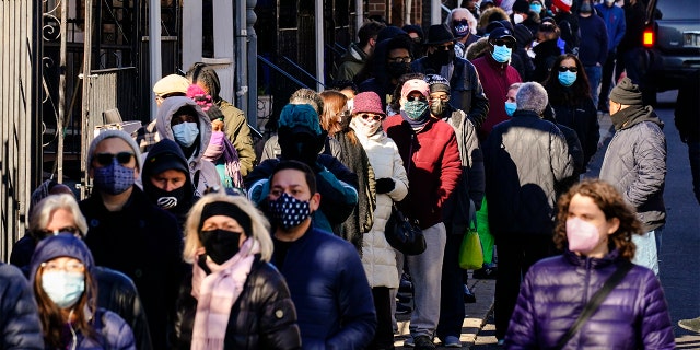 City residents wait in a line extending around the block to receive free at-home rapid COVID-19 test kits in Philadelphia, Monday, Dec. 20, 2021. (AP Photo/Matt Rourke)