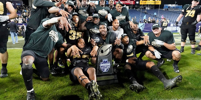 Purdue players celebrate with their trophy after beating Tennessee in overtime to win the Music City Bowl NCAA college football game Thursday, Dec. 30, 2021, in Nashville, Tennessee.