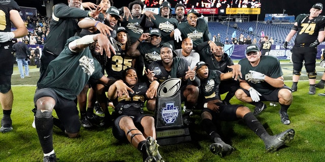 Purdue players celebrate with their trophy after beating Tennessee in overtime to win the Music City Bowl NCAA college football game Thursday, Dec. 30, 2021, in Nashville, Tennessee.