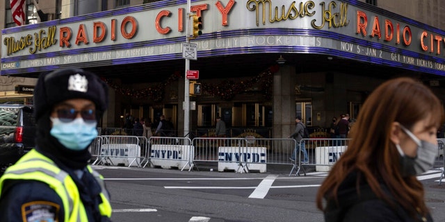 People stand in front of Radio City Music Hall after cancelations of The Rockettes performance due to COVID-19 cases on Friday, Dec. 17, 2021.
