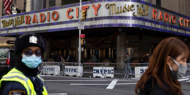 People stand in front of Radio City Music Hall after cancelations of The Rockettes performance due to COVID-19 cases on Friday, Dec. 17, 2021.