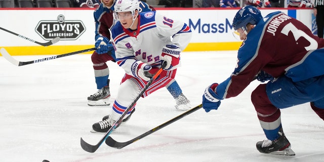 New York Rangers center Ryan Strome, center, drives past Colorado Avalanche defenseman Jack Johnson, right, as left wing J.T. Compher trails the play in the second period of an NHL hockey game Tuesday, Dec. 14, 2021, in Denver.