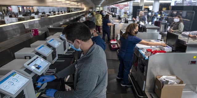 Medical workers are seen at a Dignity Health-GoHealth Urgent Care Covid-19 testing site in the international terminal at San Francisco International Airport on Dec. 2, 2021.