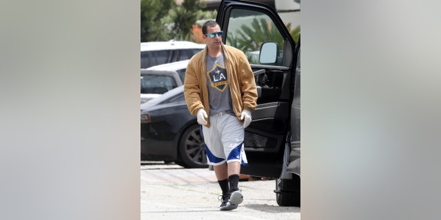 Sandler's must-have look, which he's widely known for, includes basketball shorts, oversized tees, and a range of different shoes, including a pair of UGGs.