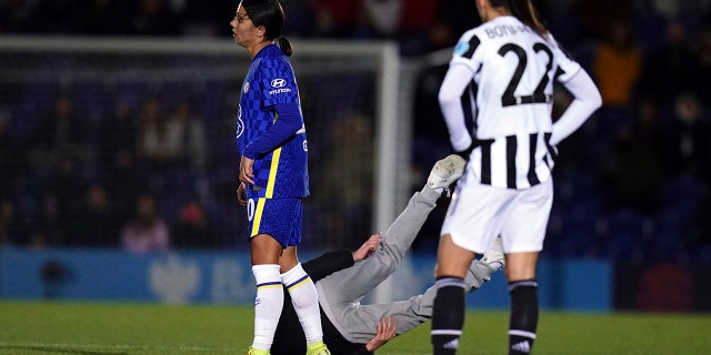A pitch invader is grounded courtesy of Chelsea's Sam Kerr during the Women's Champions League, Group A match between Chelsea and Juventus at Kingsmeadow, Londen, Woensdag, Des. 8, 2021.
