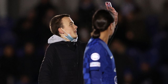 A pitch attacker tries to take a selfie with Sam Kerr of Chelsea during the UEFA Women's Champions League Group A match between Chelsea FC and Juventus at Kingsmeadow on December 08, 2021 in Kingston in Thames, England.