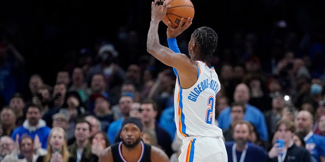 Oklahoma City Thunder guard Shai Gilgeous-Alexander (2) shoots a game-winning 3-point shot in front of Los Angeles Clippers forward Justise Winslow (20) at the end of an NBA basketball game, Saterdag, Des. 18, 2021, in Oklahoma City.