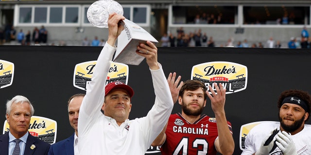 Head coach Shane Beamer of the South Carolina Gamecocks celebrates winning the Duke's Mayo Bowl over the North Carolina Tar Heels at Bank of America Stadium on December 30, 2021 in Charlotte, North Carolina.