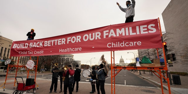 An activist dances to a band atop a street blockade near the U.S. Capitol in Washington, Dec. 7, 2021.