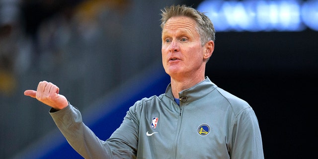 L'entraîneur des Golden State Warriors, Steve Kerr, signale aux joueurs lors du premier quart du match de basket NBA de l'équipe contre les 76ers de Philadelphie, le mercredi 24 novembre 2021, à San Francisco.