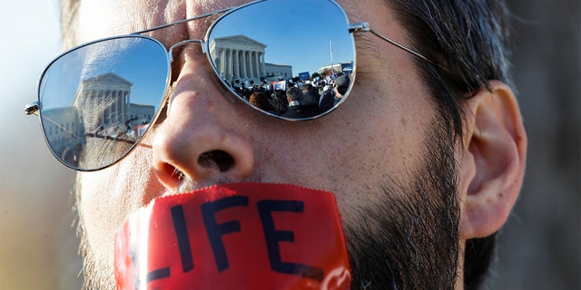 A pro-life activist attends a protest outside the Supreme Court building in Washington on Dec. 1, 2021.