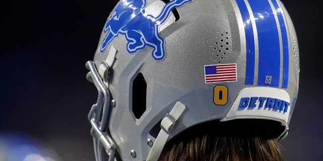 Detroit Lions offensive tackle Taylor Decker sports an Oxford decal, honoring the students killed at the high school this week, during pregame of an NFL football game against the Minnesota Vikings, 日曜日, 12月. 5, 2021, in Detroit.