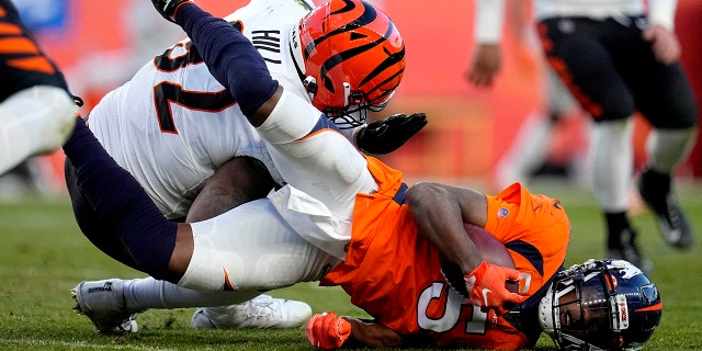 Denver Broncos quarterback Teddy Bridgewater (5) is hit by Cincinnati Bengals defensive end B.J. Hill during the second half of an NFL football game, 日曜日, 12月. 19, 2021, デンバーで. Bridgwater left the game after being injured on the play.