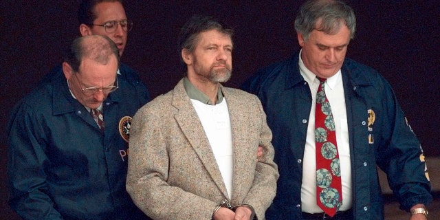 Theodore Kaczynski looks around as U.S. Marshals prepare to take him down the steps at the federal courthouse to a waiting vehicle on June 21, 1996, in Helena, Montana.
