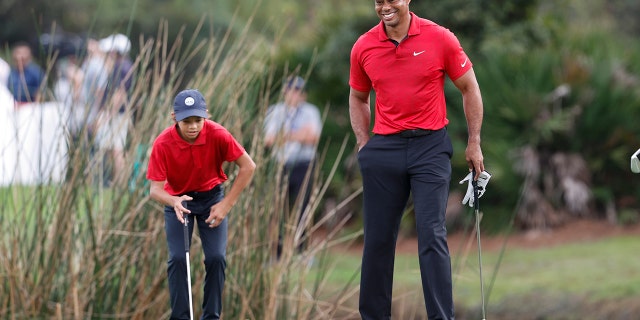 Tiger Woods smiles while walking on the second green during the second round of the PNC Championship golf tournament Sunday, 12月. 19, 2021, in Orlando, フラ.