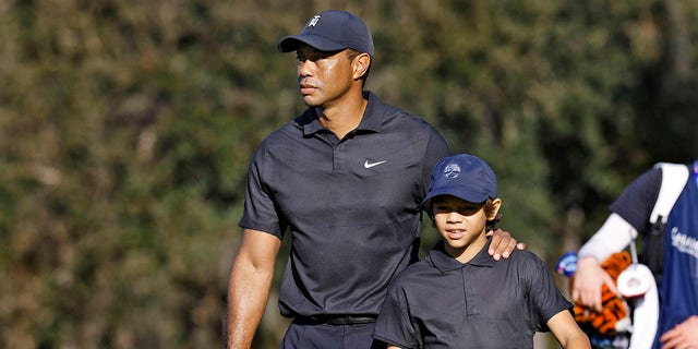 Tiger Woods, left, and his son Charlie walk the first fairway during the first round of the PNC Championship golf tournament Friday, Dec. 17, 2021, in Orlando, Florida. 