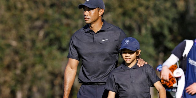 Tiger Woods, left, and his son Charlie walk the first fairway during the first round of the PNC Championship golf tournament Friday, Dec. 17, 2021, in Orlando, Florida.