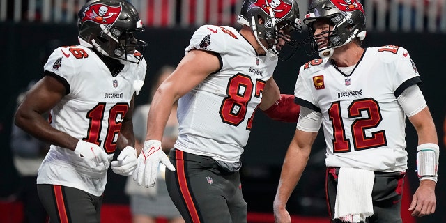Tampa Bay Buccaneers tight end Rob Gronkowski (87) celebrates his touchdown with Tampa Bay Buccaneers quarterback Tom Brady (12) during the first half of an NFL football game against the Atlanta Falcons, Sunday, Dec. 5, 2021, in Atlanta.
