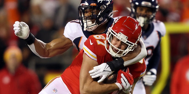 Travis Kelce (87) of the Kansas City Chiefs is tackled by Kenny Young (41) of the Denver Broncos after making a catch during the first quarter of the game at Arrowhead Stadium on Dec. 5, 2021, in Kansas City, Missouri.