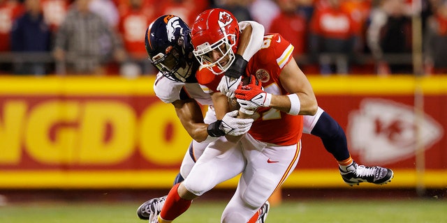 Travis Kelce of the Kansas City Chiefs is tackled by Jamar Johnson of the Denver Broncos on Dec. 5, 2021, カンザスシティで, ミズーリ.
