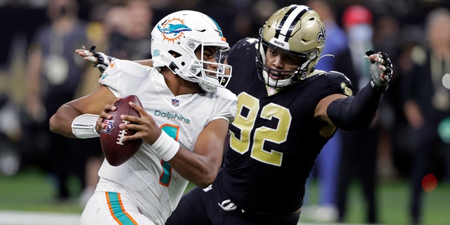 Miami Dolphins quarterback Tua Tagovailoa (1) is pressured by New Orleans Saints defensive end Marcus Davenport (92) during the second half of an NFL football game Monday, Dec. 27, 2021, in New Orleans.