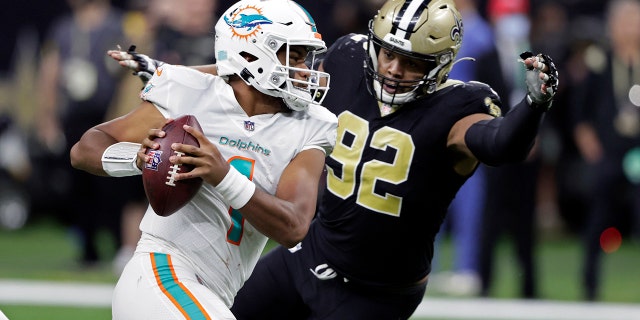Miami Dolphins quarterback Tua Tagovailoa (1) is pressured by New Orleans Saints defensive end Marcus Davenport (92) during the second half of an NFL football game Monday, Dec. 27, 2021, in New Orleans.