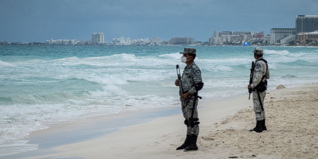 Members of the National Guard patrol a beach in the Hotel Zone of Cancun, Quintana Roo state, Mexico, on Thursday, Dec. 2, 2021. Mexico deployed a battalion of almost 1,500 National Guard troops to Cancun and surrounding beaches after two separate deadly shootouts sparked concerns over the security of the Riviera Maya region, the countrys top tourist destination. (Cesar Rodriguez/Bloomberg via Getty Images)