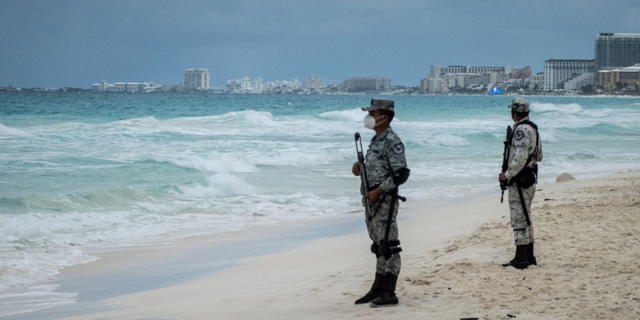 Members of the National Guard patrol a beach in the Hotel Zone of Cancun, Quintana Roo state, Mexico, on Thursday, Dec. 2, 2021. Mexico deployed a battalion of almost 1,500 National Guard troops to Cancun and surrounding beaches after two separate deadly shootouts sparked concerns over the security of the Riviera Maya region, the countrys top tourist destination. (Cesar Rodriguez/Bloomberg via Getty Images)