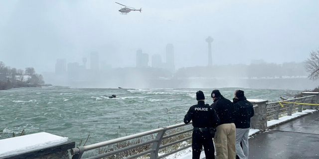 Authorities monitor an unrelated crime scene in the Niagara River near the brink of American Falls, Wednesday, Dec. 8, 2021, in Niagara Falls, N.Y.