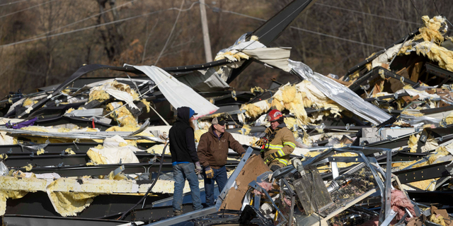Emergency workers search through what is left of the Mayfield Consumer Products Candle Factory after it was destroyed by a tornado. (Photo by John Amis / AFP) (Photo by JOHN AMIS/AFP via Getty Images)