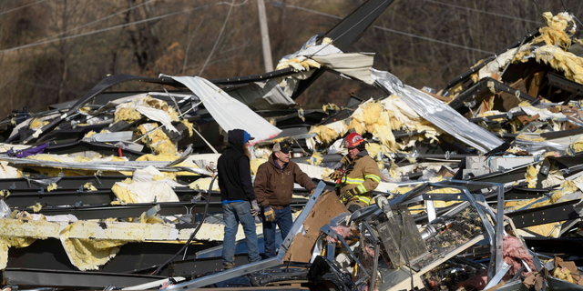 Emergency workers search through what is left of the Mayfield Consumer Products Candle Factory after it was destroyed by a tornado. (Photo by John Amis / AFP) (Photo by JOHN AMIS/AFP via Getty Images)