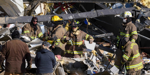 Emergency workers search through what is left of the Mayfield Consumer Products Candle Factory after it was destroyed by a tornado in Mayfield, Kentucky, on December 11, 2021. . (Photo by John Amis / AFP) (Photo by JOHN AMIS/AFP via Getty Images)