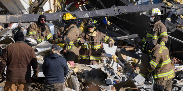 Emergency workers search through what is left of the Mayfield Consumer Products Candle Factory after it was destroyed by a tornado in Mayfield, Kentucky, on December 11, 2021. . (Photo by John Amis / AFP) (Photo by JOHN AMIS/AFP via Getty Images)