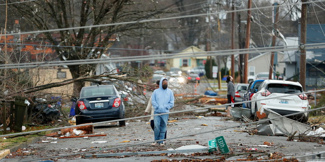 Bowling Green, Kentucky, residents look at the damage following a tornado that struck the area on December 11, 2021. - Tornadoes ripped through five US states overnight, leaving more than 70 people dead Saturday in Kentucky and causing multiple fatalities at an Amazon warehouse in Illinois that suffered "catastrophic damage" with around 100 people trapped inside. The western Kentucky town of Mayfield was "ground zero" of the storm -- a scene of "massive devastation," one official said. (Photo by Gunnar Word / AFP) (Photo by GUNNAR WORD/AFP via Getty Images)