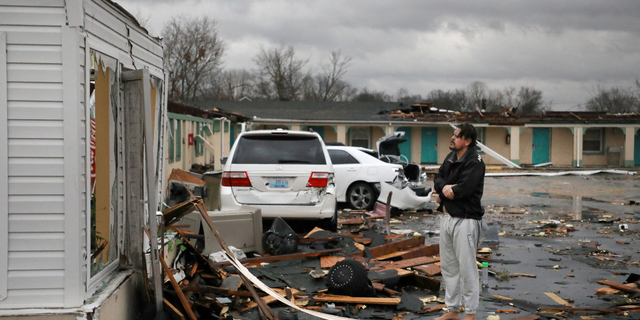 TOPSHOT - A resident of the The Cardinal Inn in Bowling Green, Kentucky, looks at the damages done after a tornado touched down on December 11, 2021. - Tornadoes ripped through five US states overnight, leaving more than 70 people dead Saturday in Kentucky and causing multiple fatalities at an Amazon warehouse in Illinois that suffered "catastrophic damage" with around 100 people trapped inside. The western Kentucky town of Mayfield was "ground zero" of the storm -- a scene of "massive devastation," one official said. (Photo by Gunnar WORD / AFP) (Photo by GUNNAR WORD/AFP via Getty Images)