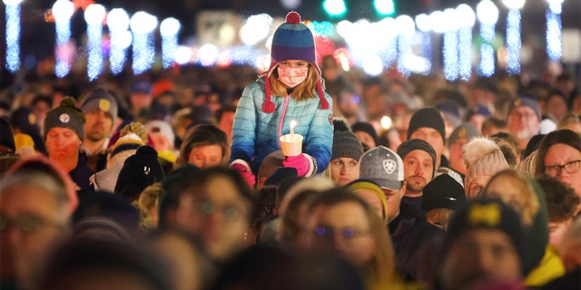 People attend a vigil downtown to honor those killed and wounded during the recent shooting at Oxford High School on December 03, 2021 in Oxford, Michigan.  (Photo by Scott Olson/Getty Images)