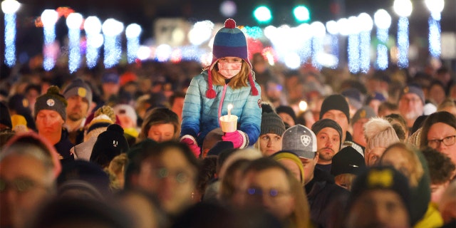 People attend a vigil downtown to honor those killed and wounded during the recent shooting at Oxford High School on December 3, 2021 in Oxford, Michigan. (Photo by Scott Olson/Getty Images)