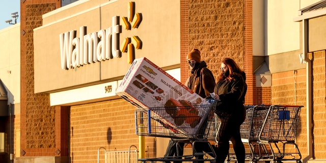 FILE: Black Friday shoppers walk out of Walmart with a full shopping cart on November 26, 2021 in Westminster, Colorado. (Photo by Michael Ciaglo/Getty Images)