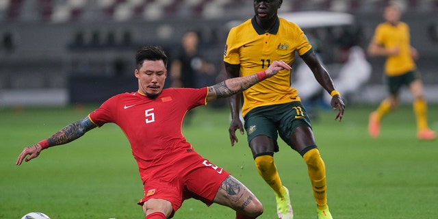 Zhang Linpeng tackles Awer Mabil during Australia v. China PR - 2022 FIFA World Cup Qualifier at Khalifa International Stadium on Sept. 2, 2021, in Doha, Qatar.