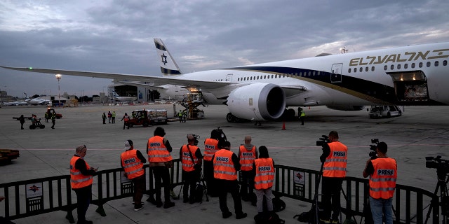 Journalists in reflective vests cover a shipment of Pfizer's antiviral COVID-19 pill, Paxlovid, on arrival at Ben Gurion International airport near Tel Aviv, Thursday, Dec. 30, 2021.