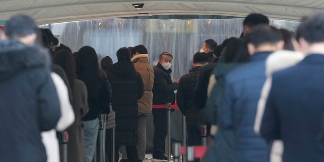 People wait for their coronavirus test at a makeshift testing site in Seoul, South Korea, Thursday, Dec 16, 2021.