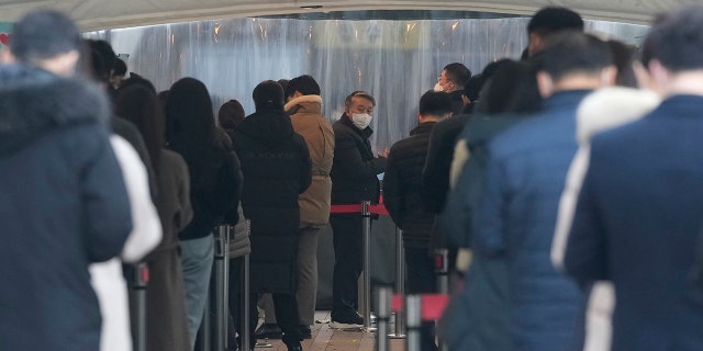 People wait for their coronavirus test at a makeshift testing site in Seoul, South Korea, Thursday, Dec 16, 2021.