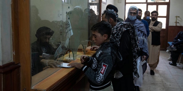 Taliban authorities check passports at the Afghanistan-Iran border crossing of Islam Qala, on Wednesday, Nov. 24, 2021.