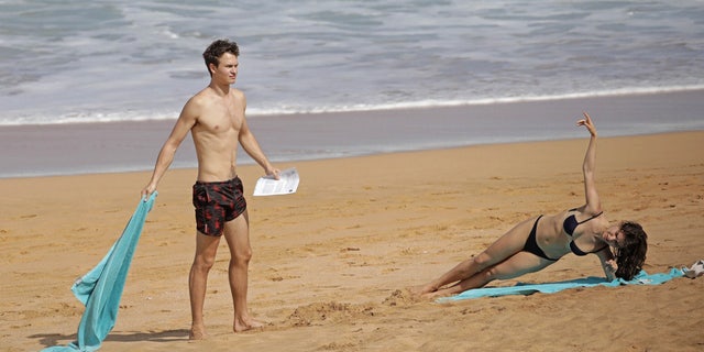 Komyshan, a trained dancer, appeared to work up a sweat on her beach towel as she performed a side plank.