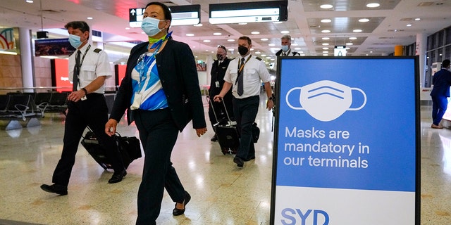 A flight crew walks through the terminal at Sydney Airport on Nov. 29, 2021.